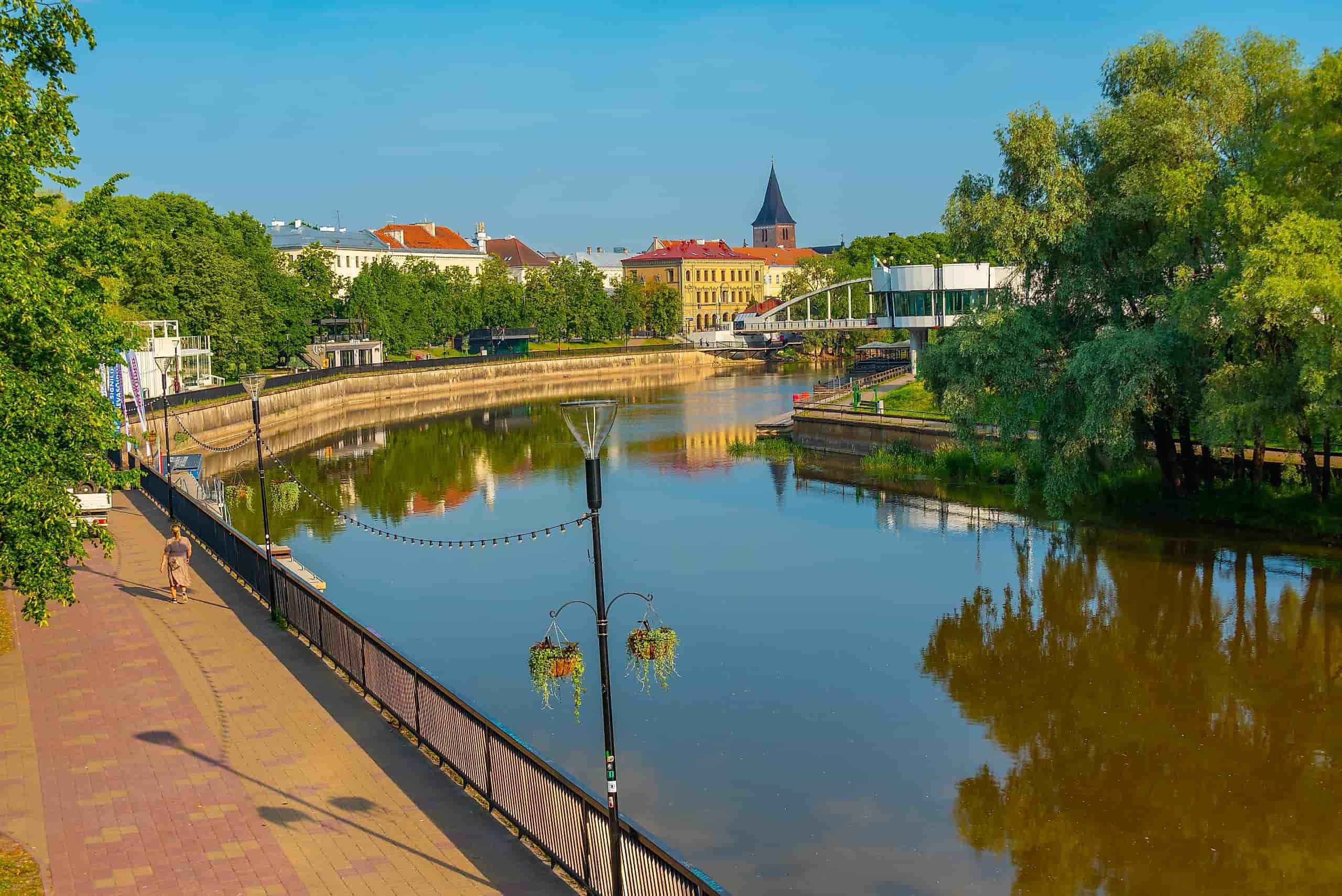 This image depicts a scenic view of the Emajõgi River flowing through the city of Tartu, Estonia