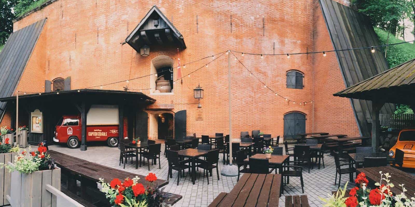This image shows the outdoor terrace of the Gunpowder Cellar of Tartu (Püssirohukelder), a historic restaurant located in Estonia.
