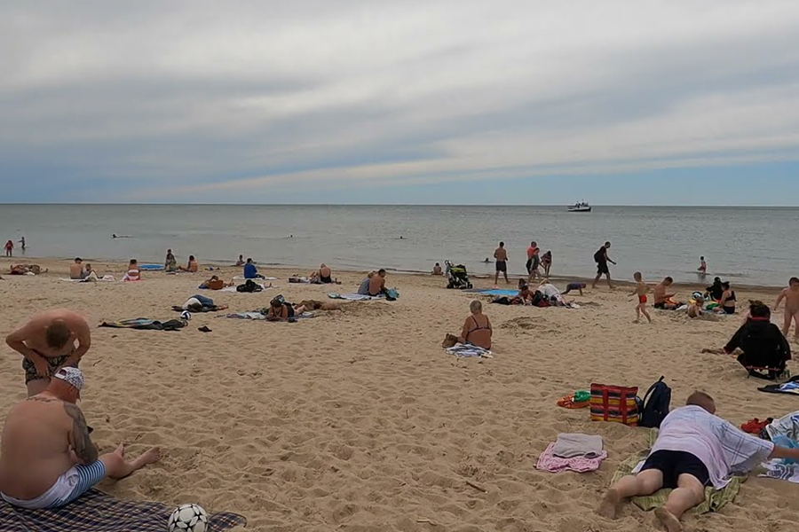 Tourists relaxing on a sandy beach along the Baltic Sea in Lithuania.