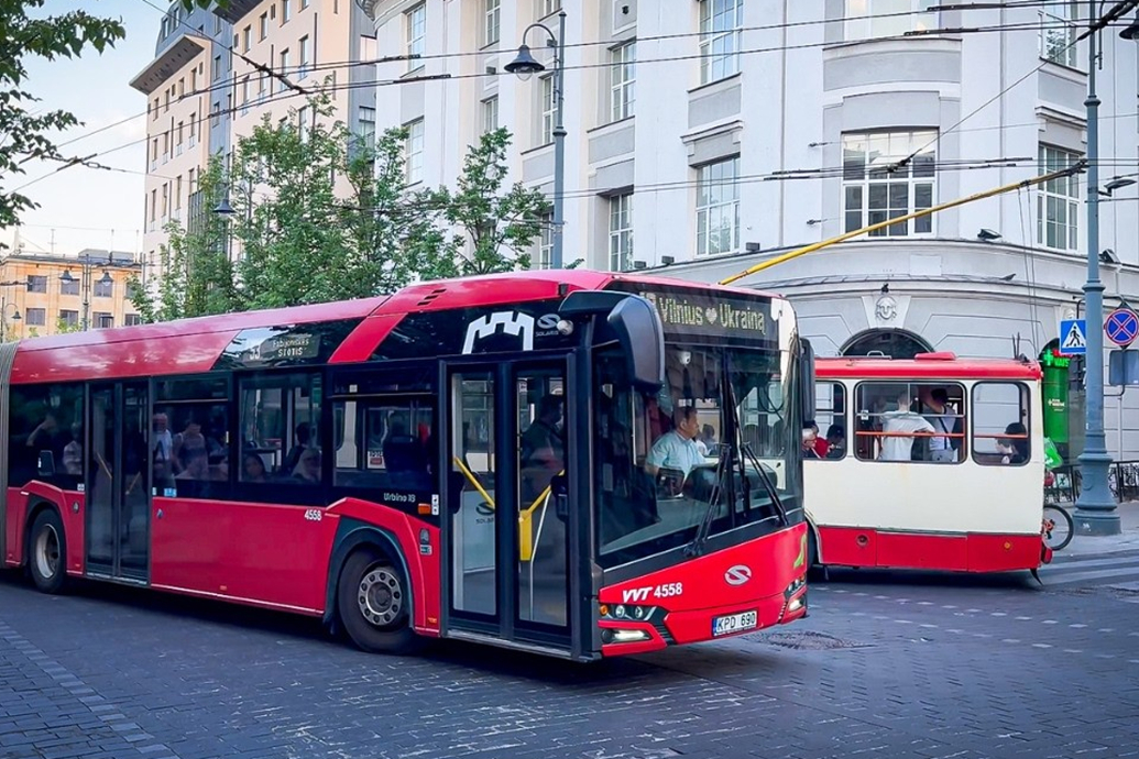 Red articulated public bus on a street in Vilnius, Lithuania.