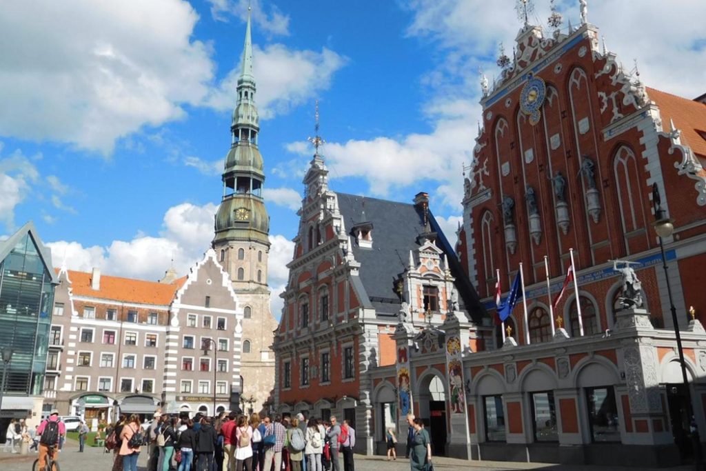 Riga Town Hall Square with historic buildings and tourists.