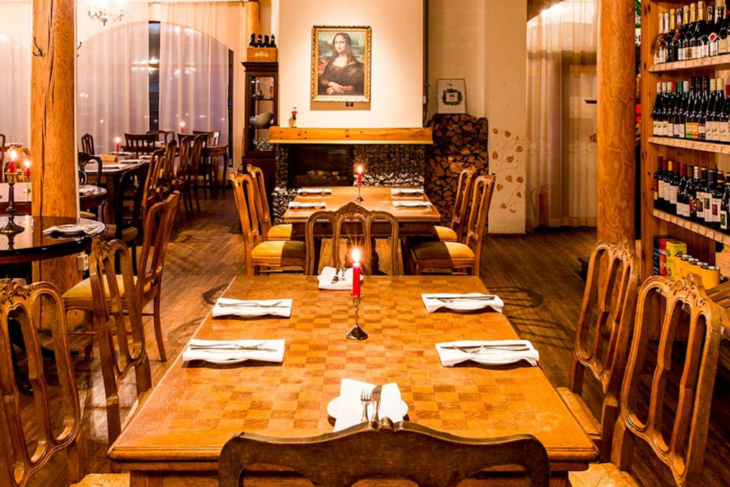 Cozy European restaurant with wooden tables and candlelight.